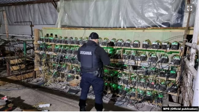 Một cảnh sát Kosovo kiểm tra các thiết bị đào tiền điện tử trong một cuộc truy quét tại Leposavic
